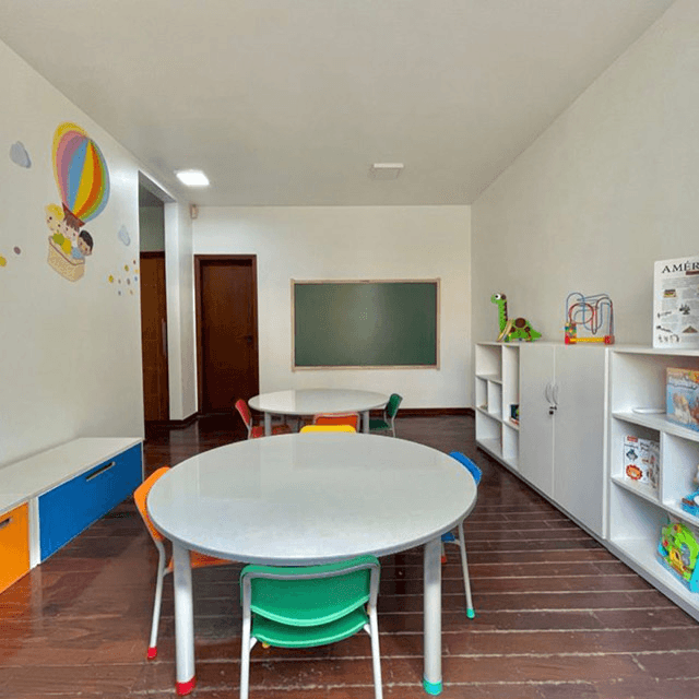 Sala de aula com mesas redondas coloridas